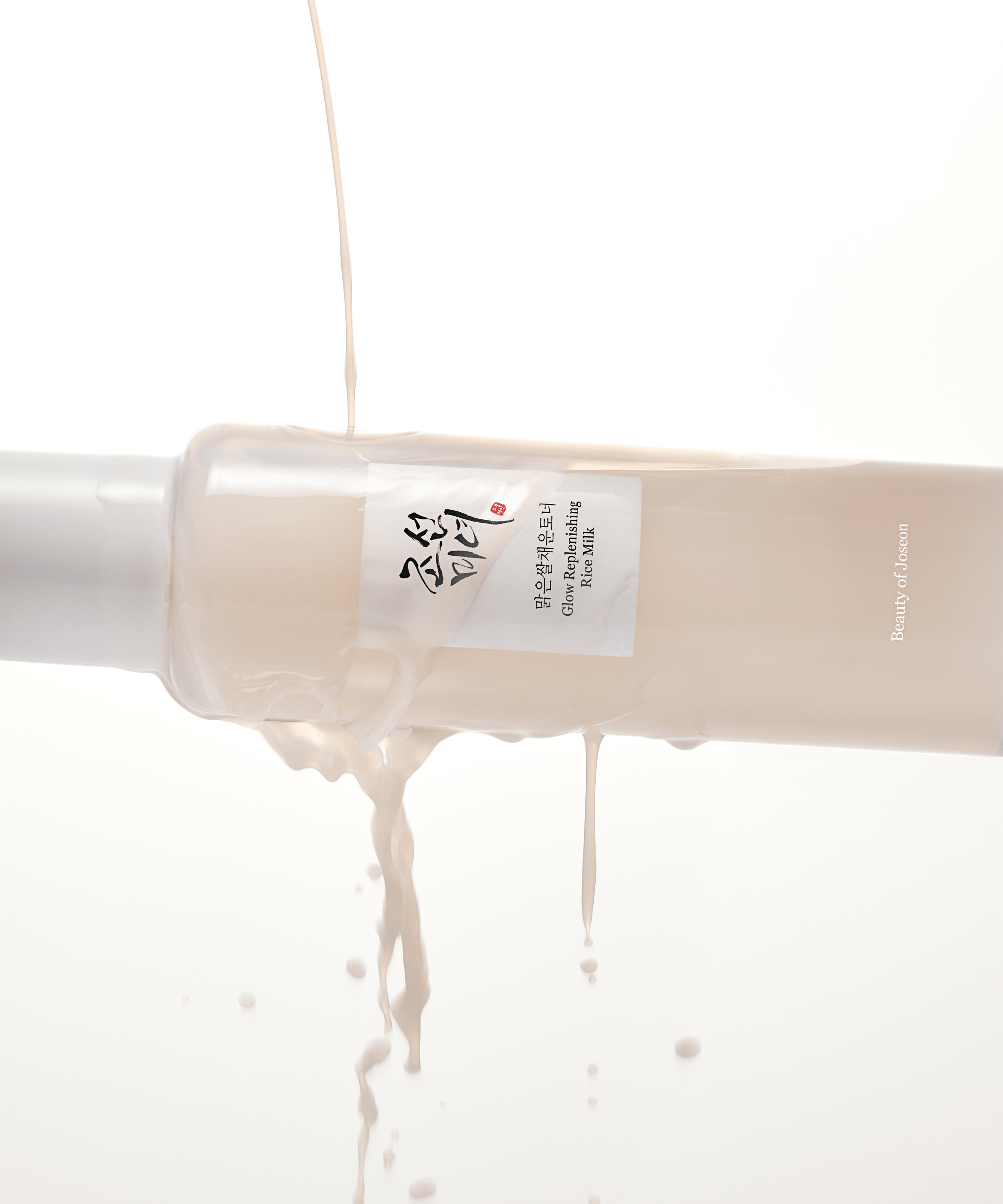 BEAUTY OF JOSEON Glow Replenishing Rice Milk 150ml, flacon crème sur fond clair, textures onctueuses en gouttes