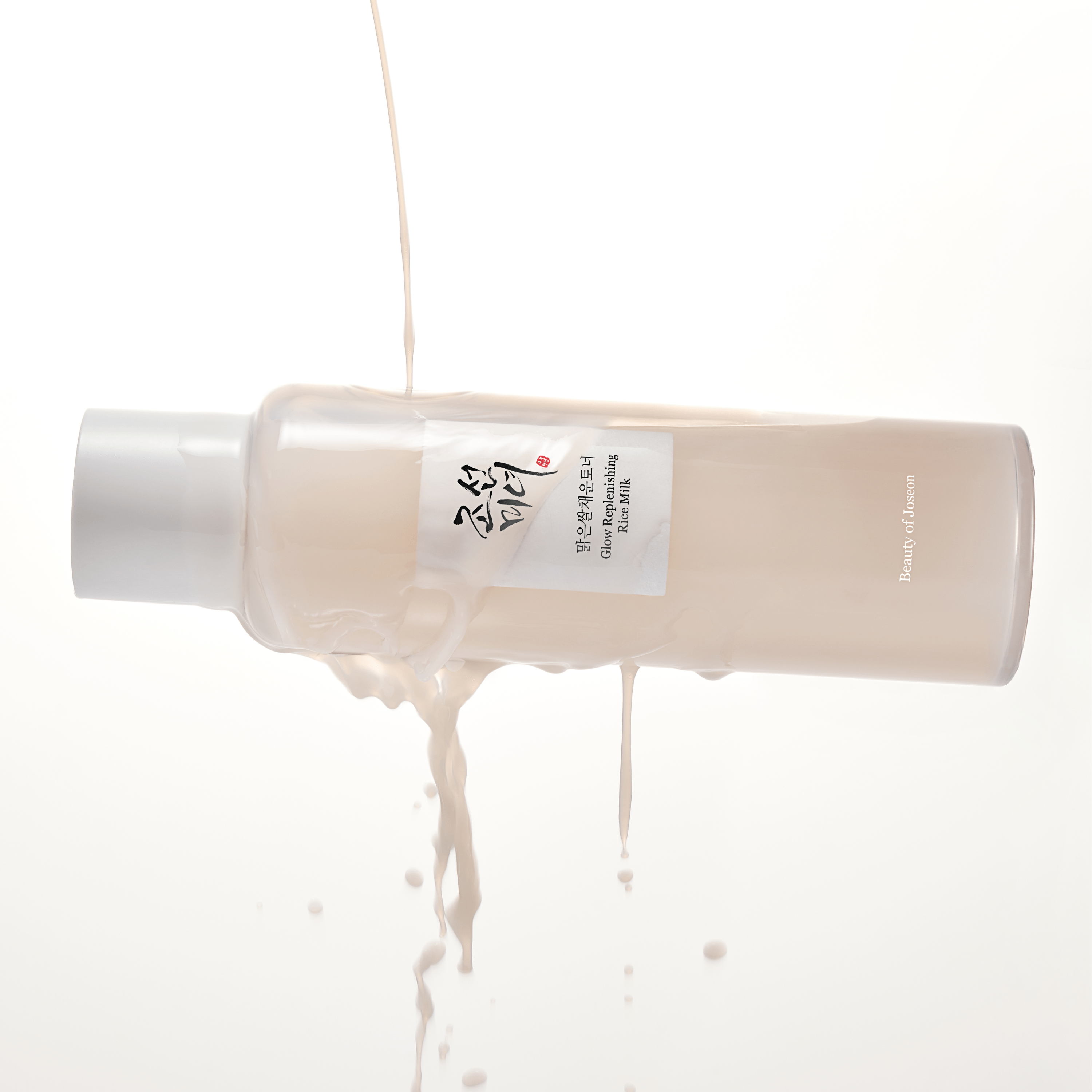BEAUTY OF JOSEON Glow Replenishing Rice Milk 150ml, flacon crème sur fond clair, textures onctueuses en gouttes