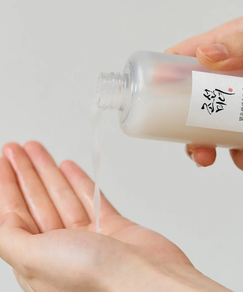 BEAUTY OF JOSEON Glow Replenishing Rice Milk 150ml, marque en flacon, mains appliquant une crème luisante, contexte soins.