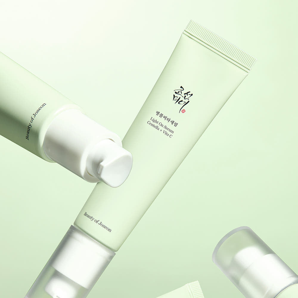Décris l'image en français: BEAUTY OF JOSEON Light On Serum Centella+ Vita C 30ml, tubes crème en fond vert clair.