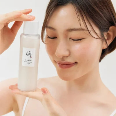 BEAUTY OF JOSEON Glow Replenishing Rice Milk 150ml : femme applique lait visage, flacon blanc sur fond clair, marque Beauty of Joseon