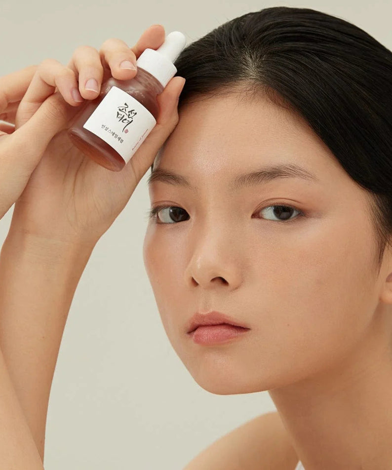 BEAUTY OF JOSEON Ginseng Snail Serum 30ml, femme applique un sérum à la crème sur le visage, photo produit en studio.
