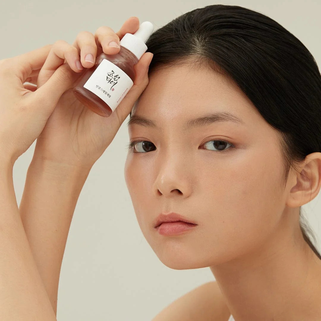 BEAUTY OF JOSEON Ginseng Snail Serum 30ml, femme applique un sérum à la crème sur le visage, photo produit en studio.