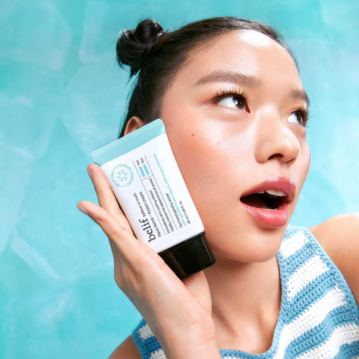 BELIF Aqua Bomb Frozen Cream 50ml : crème visage fraîche de la marque BELIF, présentée sur une femme, fond bleu.