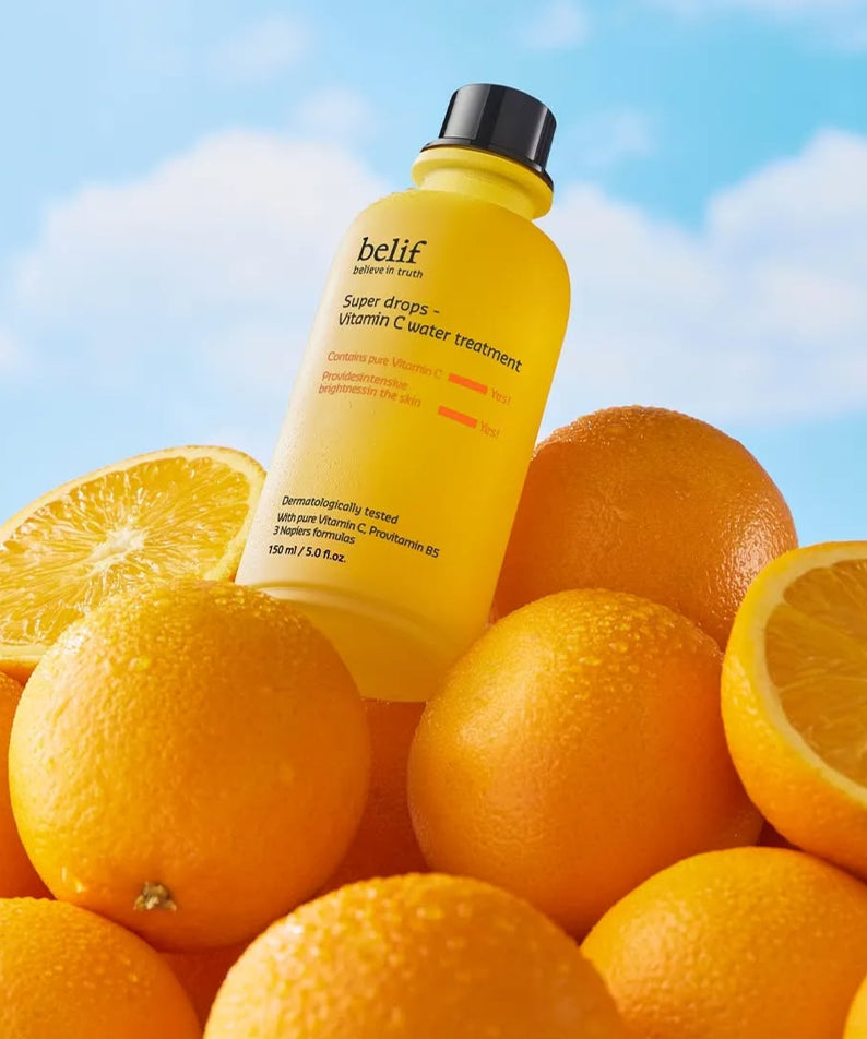 BELIF Super Drops-Vitamin C Water Treatment 150ml sur des oranges sous un ciel bleu.