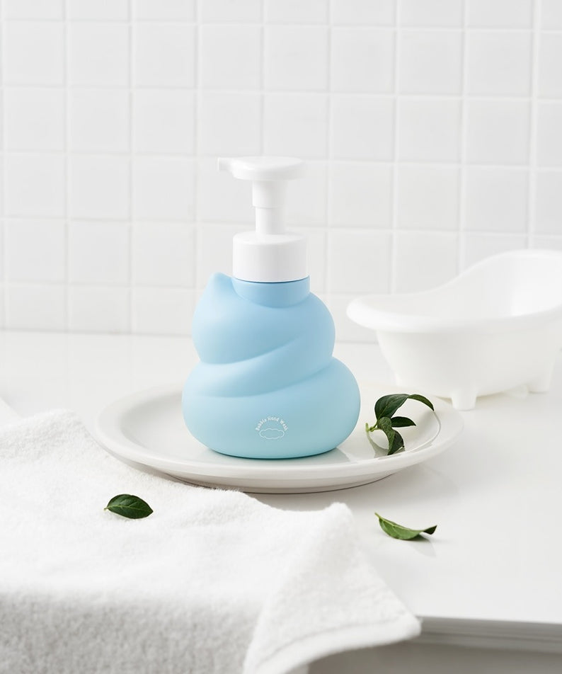 BELLBOY STUDIO Hippong Bubble Hand Wash : flacon bleu mousseux sur plateau près d’une salle de bain, serviettes et fleurs.