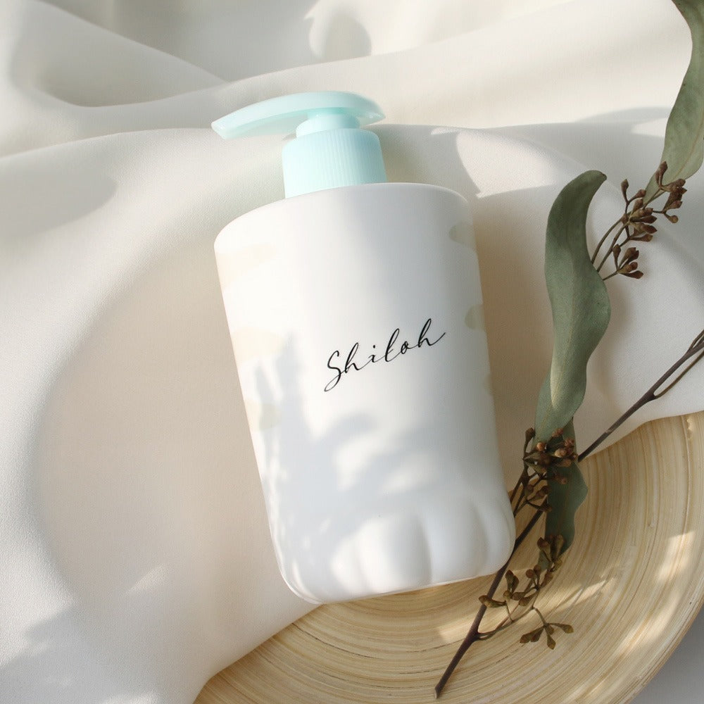 BELLBOY STUDIO Silky Shiloh Prime Shampoo 400ml sur fond clair, bouteille blanche avec fleurs séchées et lumière naturelle