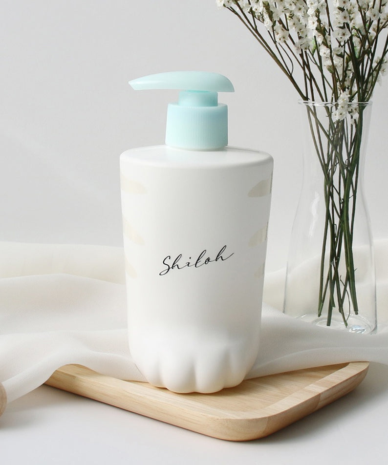 Shampoo BELLBOY STUDIO Silky Shiloh Prime 400ml sur une table en bois avec des fleurs blanches