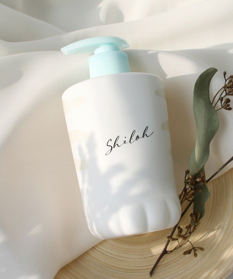 Bouteille de 400ml de BELLBOY STUDIO Silky Shiloh Prime Shampoo posée sur un tissu clair, à côté de branches d'eucalyptus.