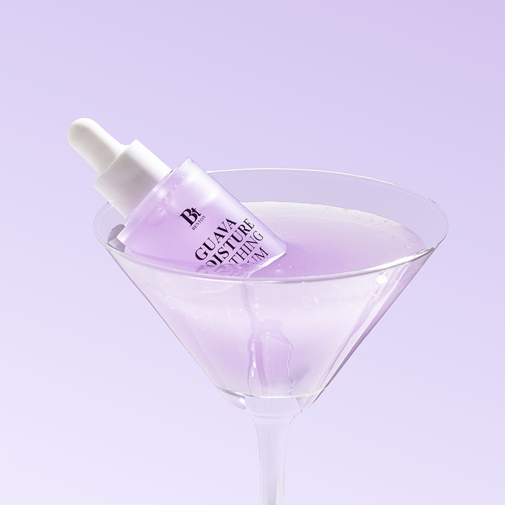 Décris l’image en français : BENTON Guava Moisture Soothing Ampoule PDRN 30ml, flacon sérum avec gouttes sur fond violet