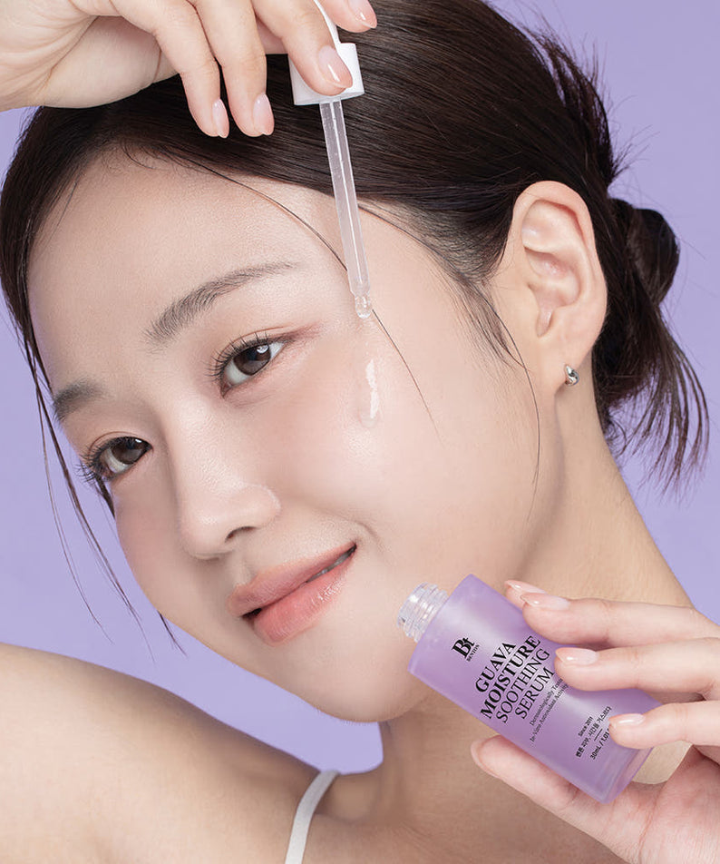 BENTON Guava Moisture Soothing Ampoule PDRN 30ml, marque Benton : la main applique le sérum sur le visage, fond violet