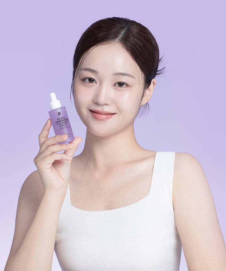 Portrait, femme tenant BENTON Guava Moisture Soothing Ampoule PDRN 30ml sur fond violet, peau hydratée.