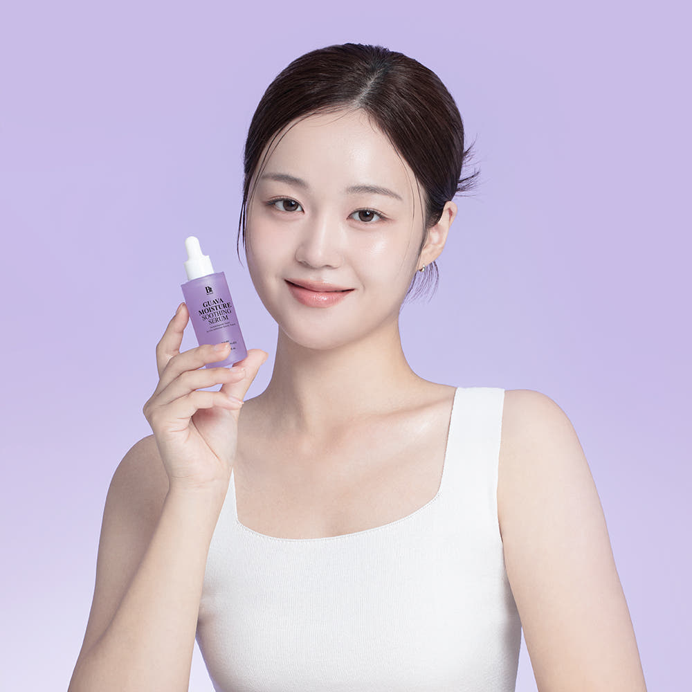 Portrait, femme tenant BENTON Guava Moisture Soothing Ampoule PDRN 30ml sur fond violet, peau hydratée.