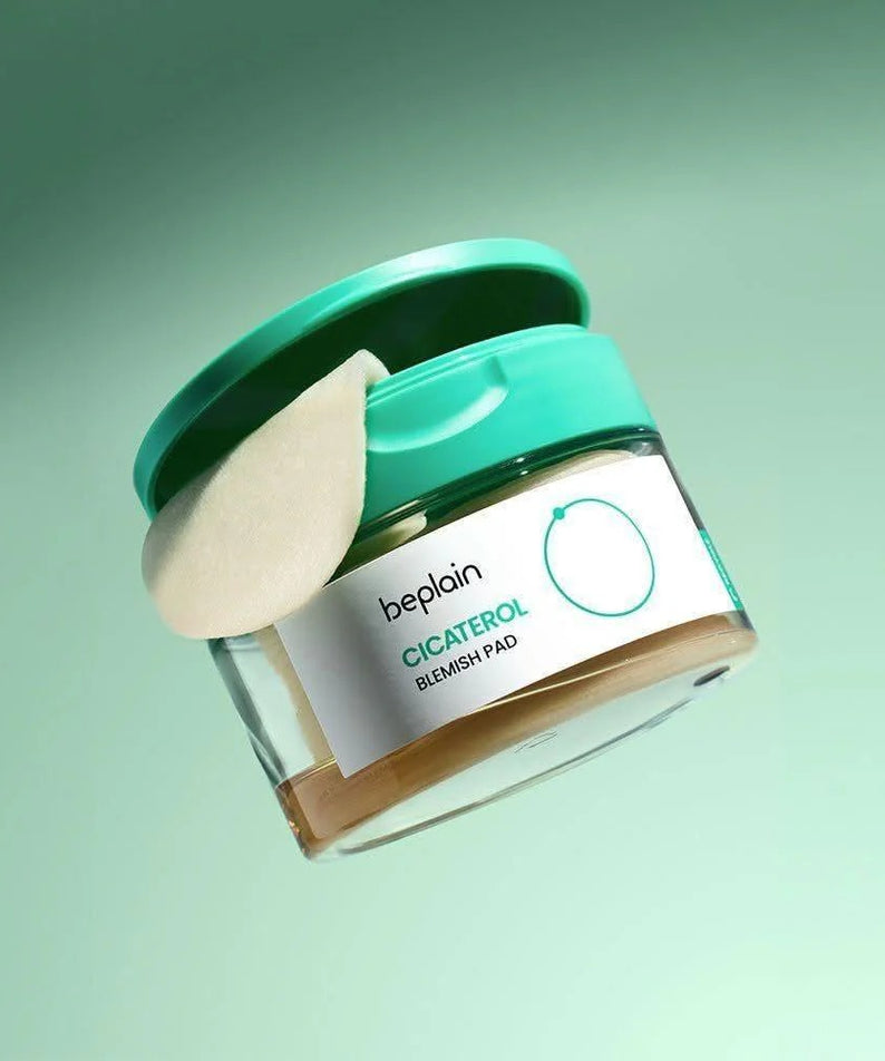 BEPLAIN Cicaterol Blemish Pad 80 sheets, coussinets anti-imperfections à l’aspect blanc, flacon vert sur fond vert pastel.