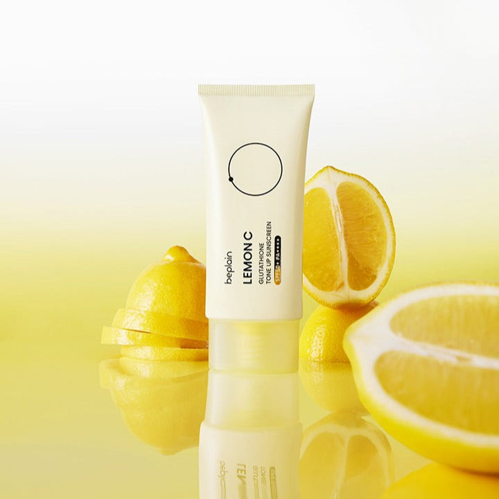 BEPLAIN Lemon Seed Glutathione Tone-up Sun Cream 50ml, tube sur citrons et fond jaune en contexte cosmétique.