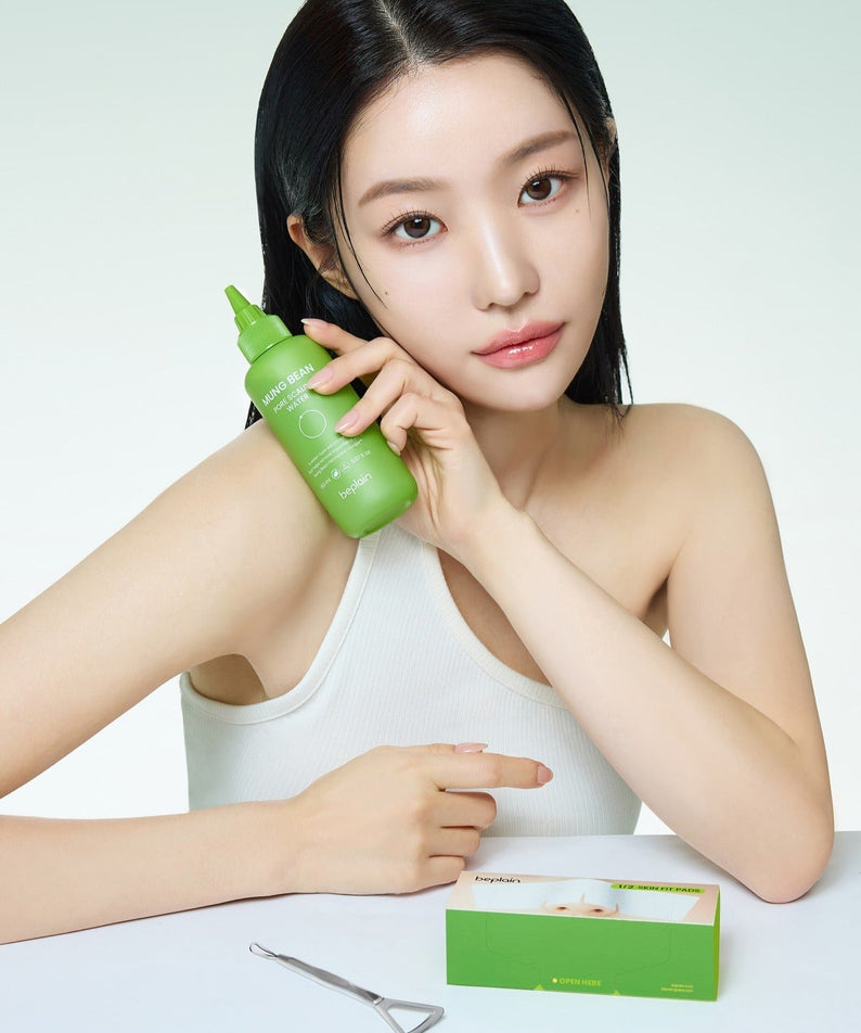 Femme posant avec BEPLAIN Green Bean Pore Scaling Water 150ml, produit naturel pour le soin de la peau, bouteille verte visible.
