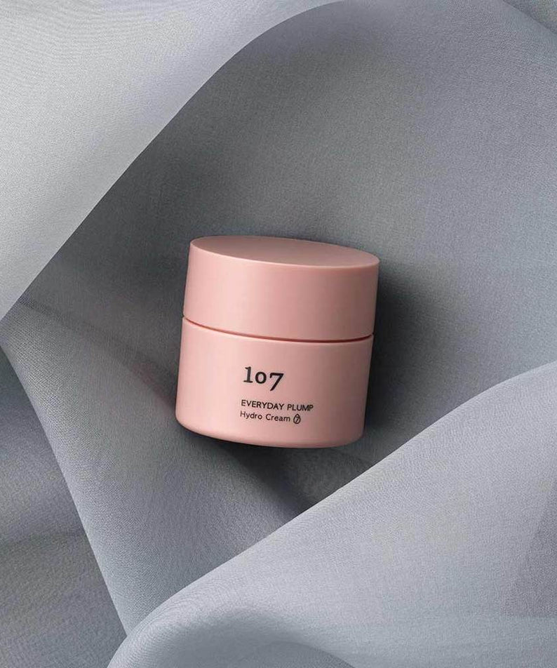 107 Everyday plump Hydro Cream 50ml de la marque 107, pot crème rose sur tissu gris drapé, ambiance soin visage