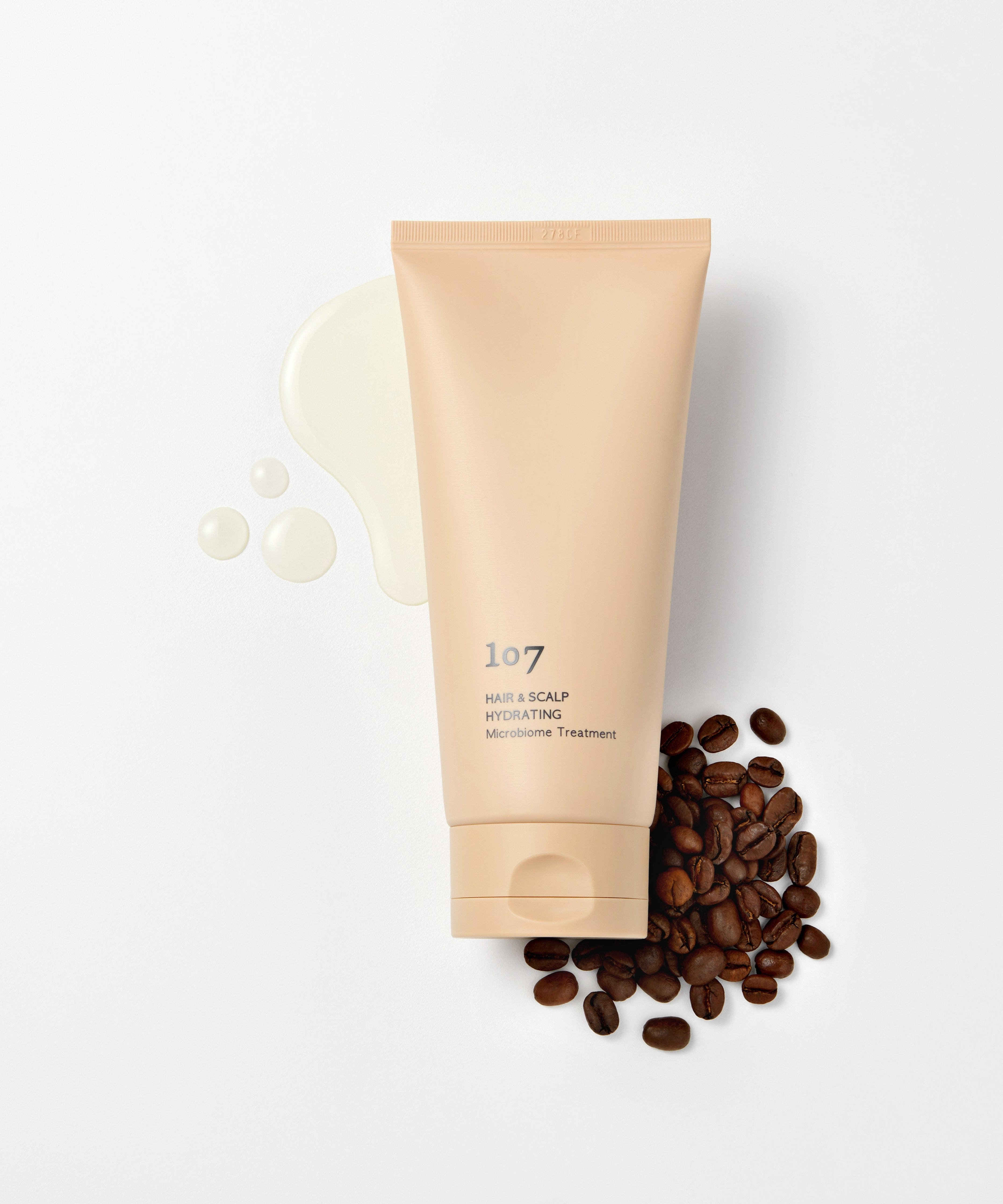 107 Hair & Scalp Hydrating Microbiome Treatment 180ml de 107, tube beige sur fond clair avec grains de café