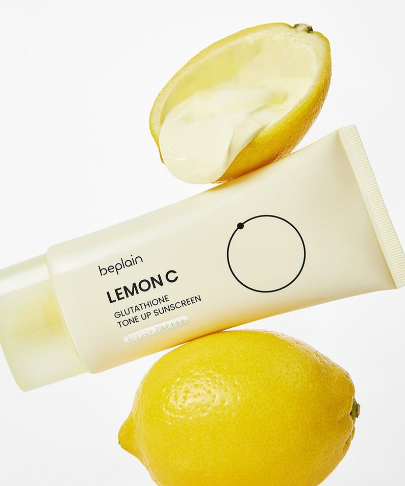 Crème solaire BEPLAIN Lemon Seed Glutathione Tone-up 50ml posée sur citrons frais. Protection solaire. Skincare éclatante et tonifiante.