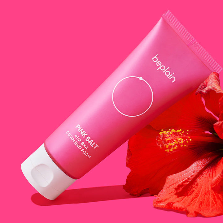 BEPLAIN Pink Salt AHA BHA Cleansing Foam 120ml de la marque beplain sur fond rose, visuel produit et fleurs rouges.