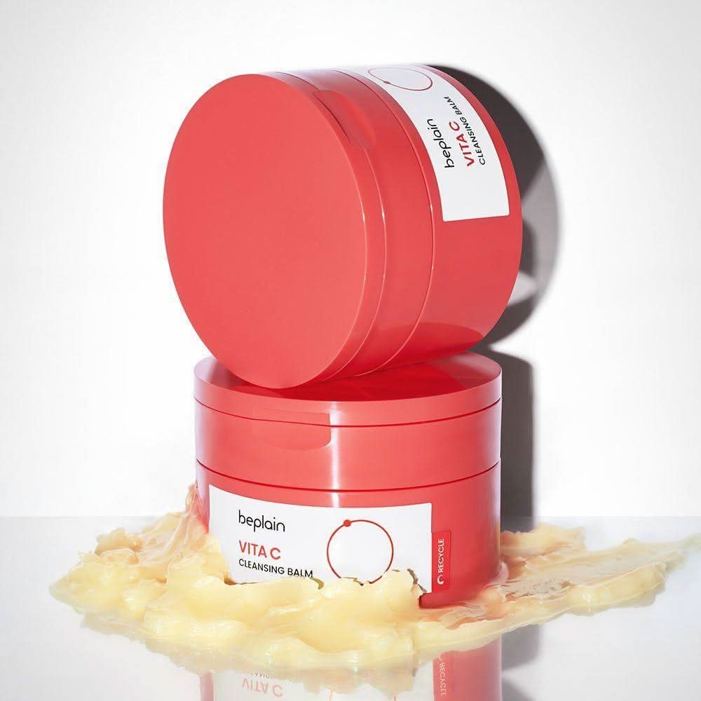 BEPLAIN Vita C Cleansing Balm 100ml de beplain, pot rouge sur fond blanc, texture crème et éclaboussures.