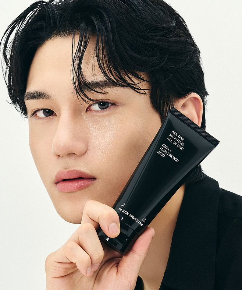 BLACK MONSTER All-Day Moisturizing All-in-One : tube noir sur visage homme, peau hydratée, fond blanc.