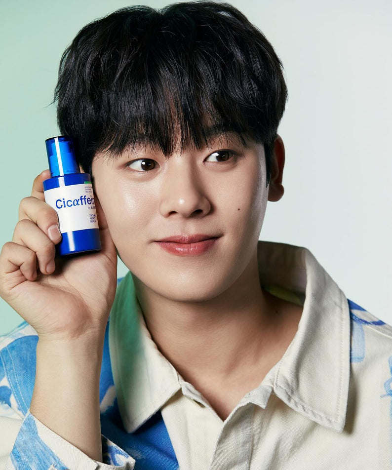 Homme souriant tient le B.READY Cicaffein trouble Reset Serum 40ml, produit de soin visage efficace et innovant.