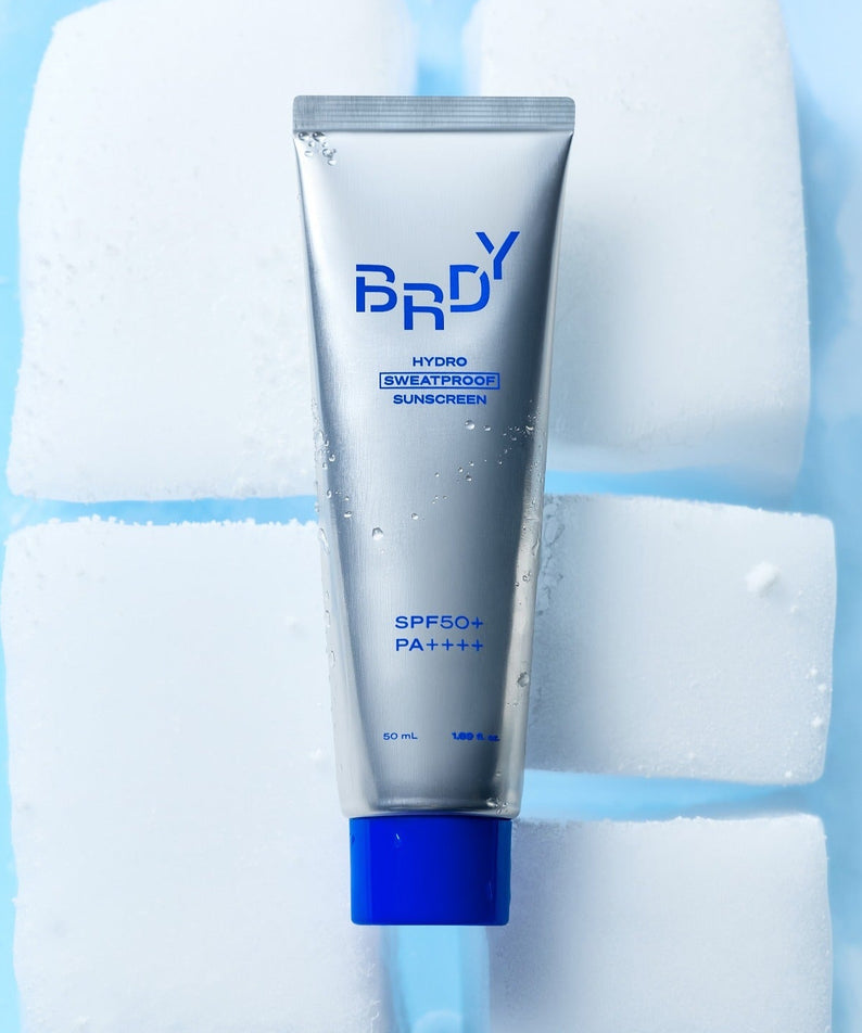 B.READY Hydro Sweatproof Sunscreen 50ml de la marque B.READY, tube bleu sur glaçons, soleil et eau, ambiance fraîche