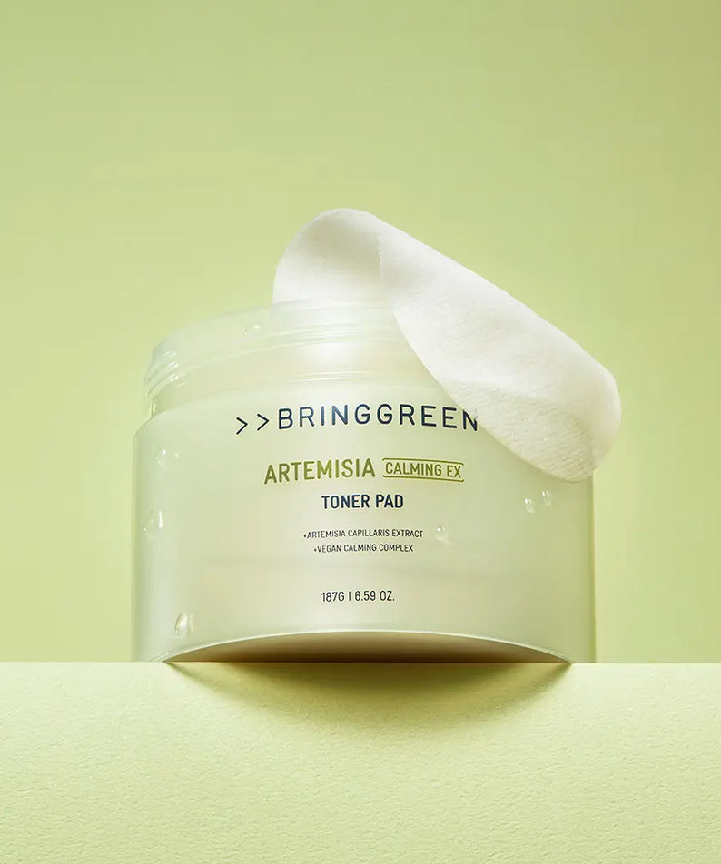 BRINGGREEN Mugwort Calming EX Toner Pads 75 Sheets, pack sur fond vert, coussin de coton blanc, style apaisant.