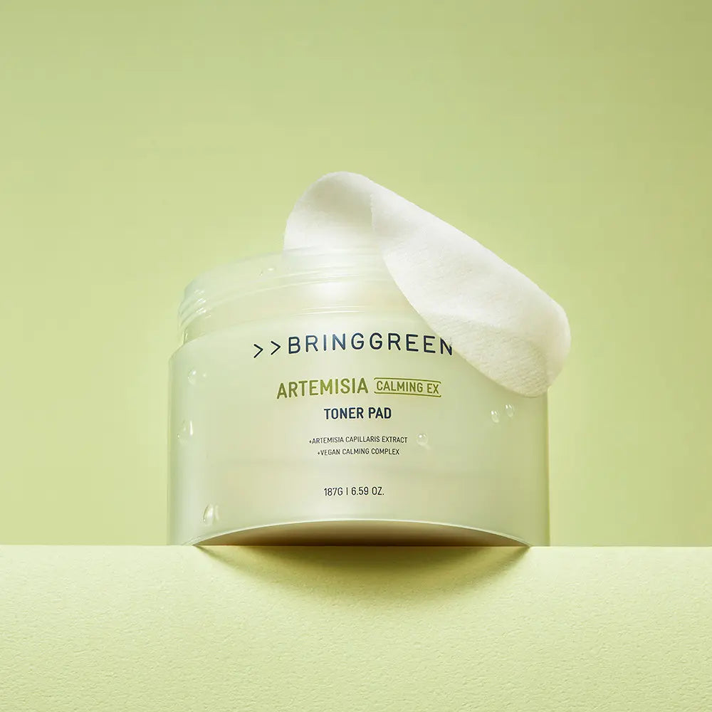 BRINGGREEN Mugwort Calming EX Toner Pads 75 Sheets, pack sur fond vert, coussin de coton blanc, style apaisant.