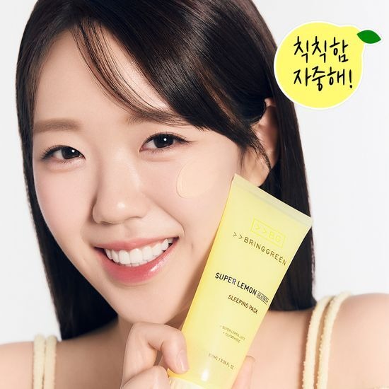 BRINGGREEN Super Lemon Glutathione Sleeping Pack 100mL, femme souriante tenant le produit; pack jaune et citron, visage.
