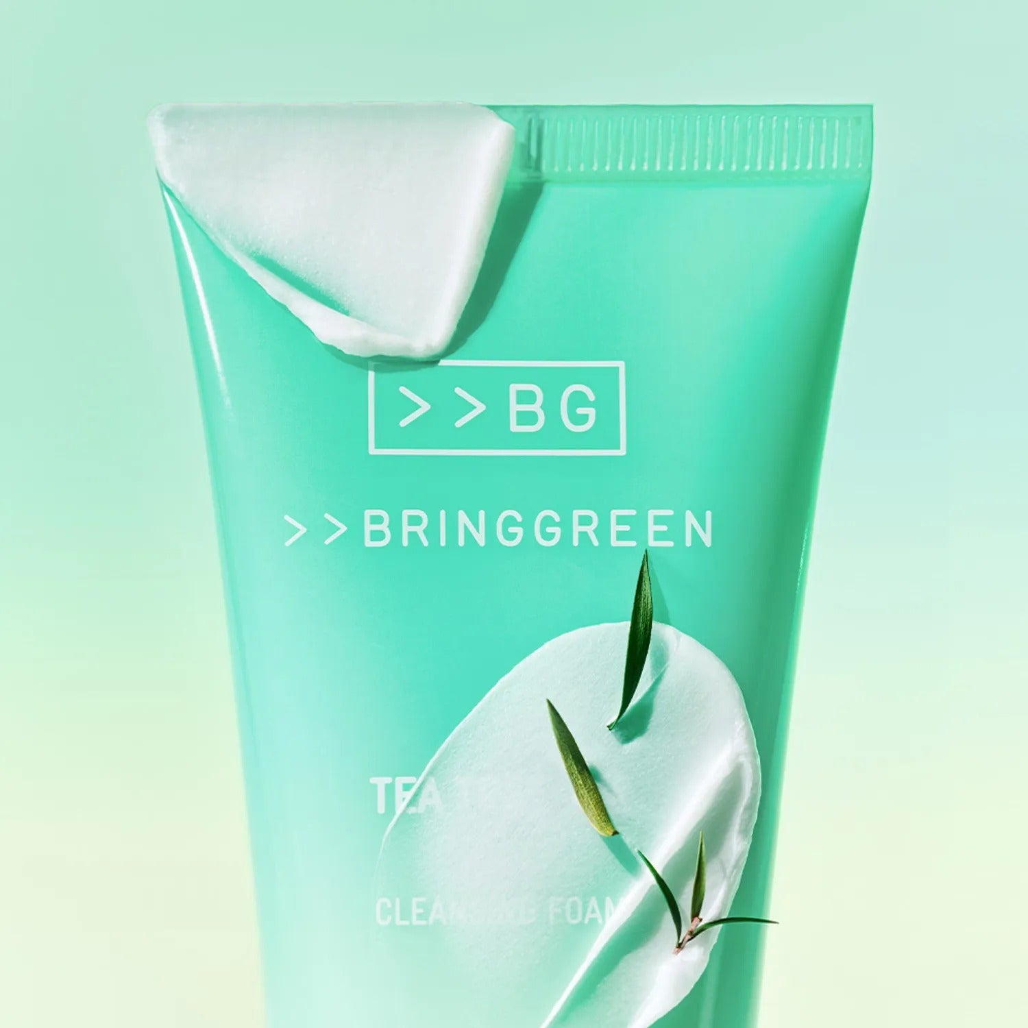 BRINGGREEN Tea Tree Cica Deep Cleansing Foam 120ml, tube turquoise sur fond vert, marque BRINGGREEN, feuilles de thé