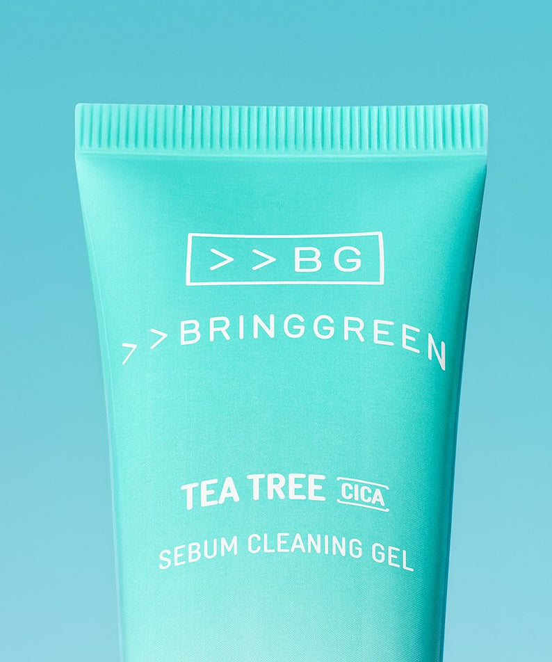 Décris l'image en français : BRINGGREEN Tea Tree Cica Sebum Cleansing Gel 50ml, tube vert sur fond bleu.
