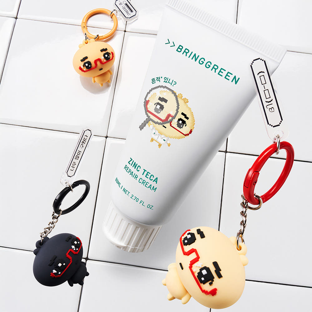 BRINGGREEN Zinc Teca Repair Blemish Cream 80ml de la marque BRINGGREEN, tube sur carrelage blanc, accessoires en fond.
