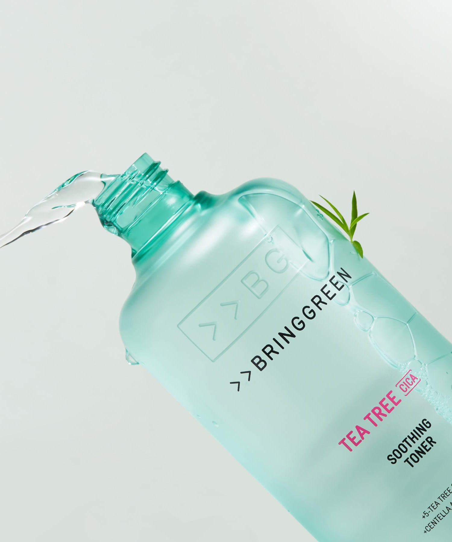 BRINGGREEN Teatree Cica Soothing Toner 250ml/500ml, flacon vert versé sur fond clair, ambiance soin visage