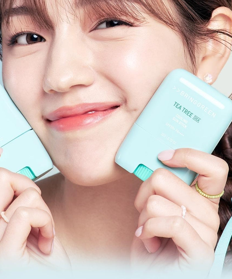 BRINGGREEN Teatree Cica Cooling Sun Stick 20g : jeune fille tenant un stick bleu ciel à la plage, marque en vue.