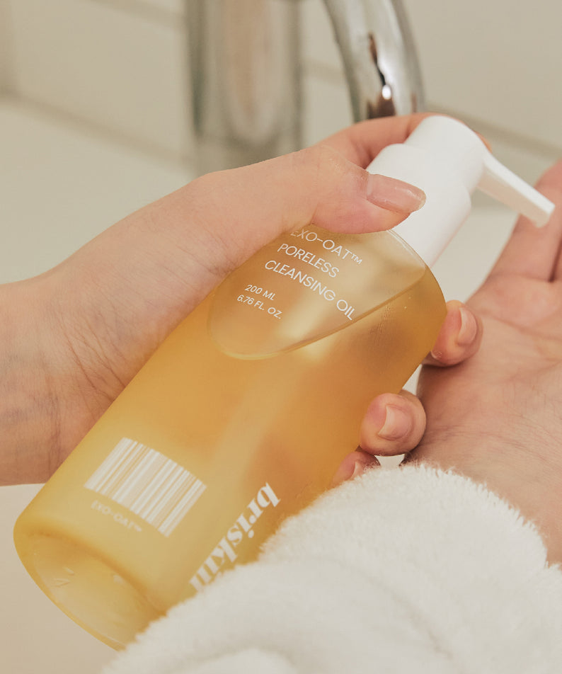 BRISKIN Exo-Oat Poreless Cleansing Oil 200ml en application sur les mains au-dessus d'un lavabo.