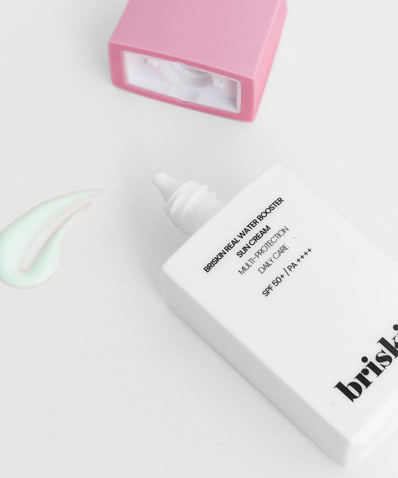 BRISKIN Real Water Booster Sun Cream SPF+PA++++ 50ml présenté avec bouchon rose et crème verte en arrière-plan.