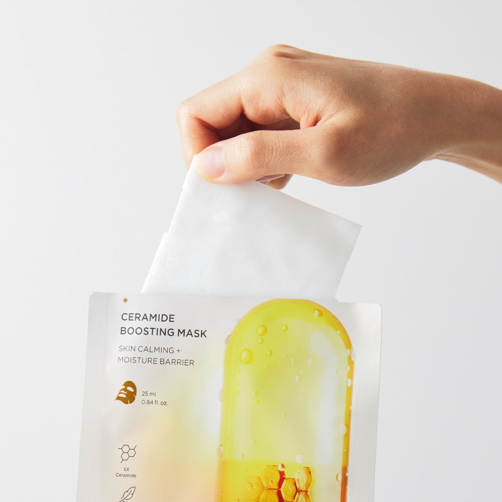 Décris l’image en français : BRTC Ceramide Boosting Mask 10 Sheets de BRTC, main tient un masque en sachet.