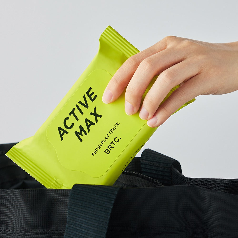 Main tenant BRTC Homme Active Max Fresh Play Tissue 15 Sheets par Action Max, lingette fraîche dans un sac noir.