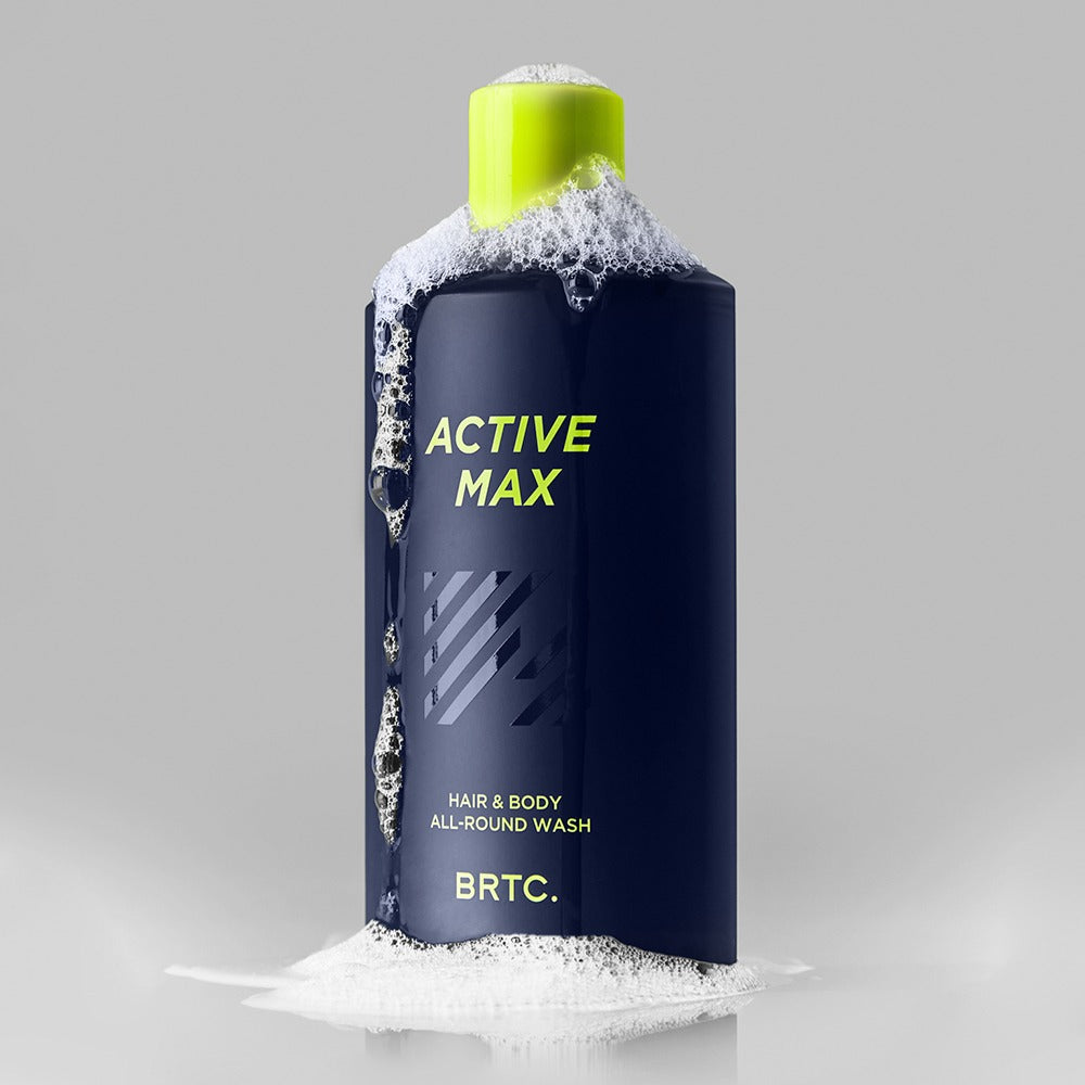 BRTC Homme Active Max Hair & Body All-Round Wash 200ml de BRTC, flacon bleu avec mousse, fond gris, homme.