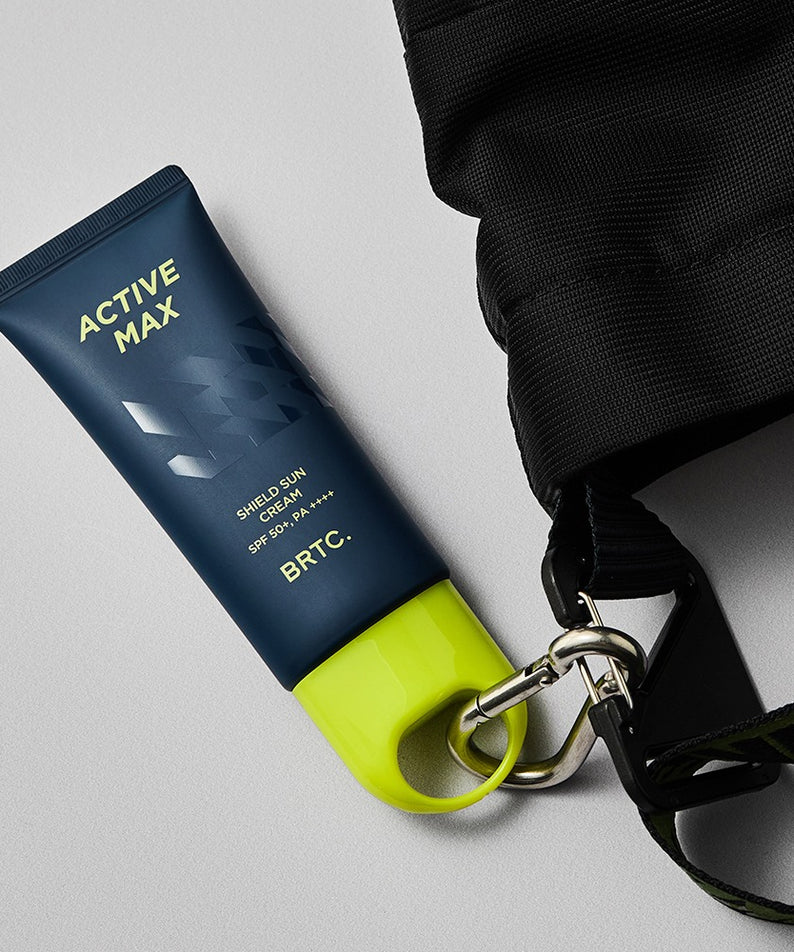 Décris l'image en français en mentionnant BRTC Homme Active Max Sheild Sunscreen 50ml de BRTC, tube sur fond gris.