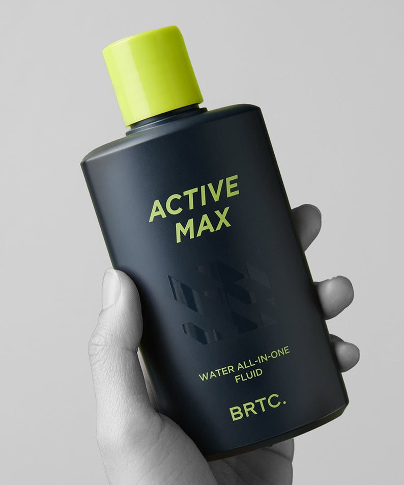 BRTC Homme Active Max Water All-in-One Fluid 150ml, flacon noir et vert tenu en main sur fond clair