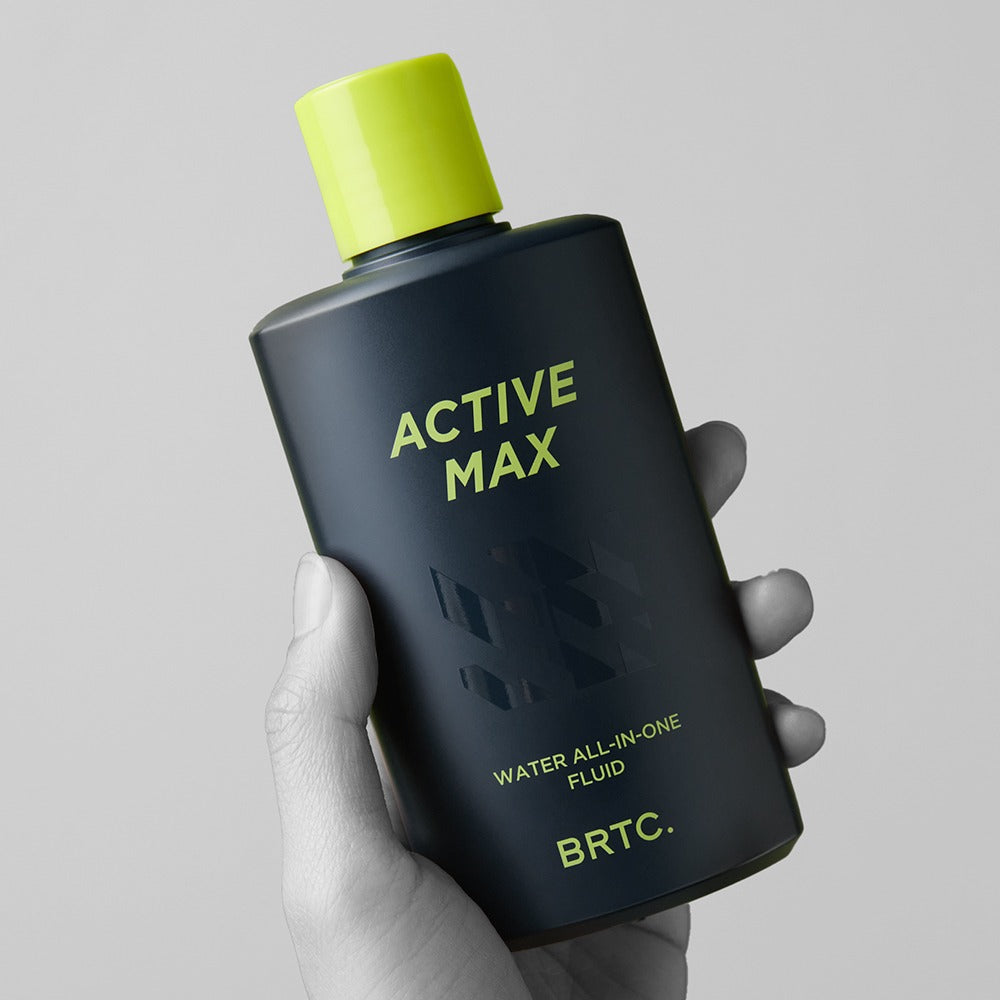 BRTC Homme Active Max Water All-in-One Fluid 150ml, flacon noir et vert tenu en main sur fond clair