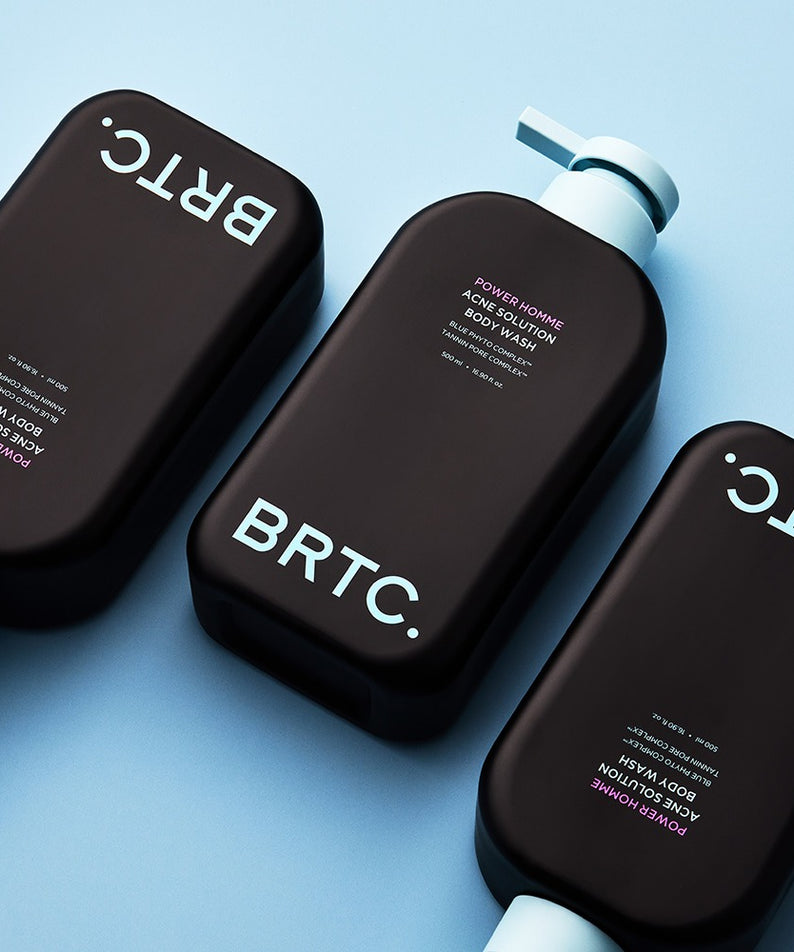 BRTC Power Homme Acne Solution Body Wash 500ml de BRTC, bouteilles sur fond bleu, contexte visuel produit cosmétique anti-acné.