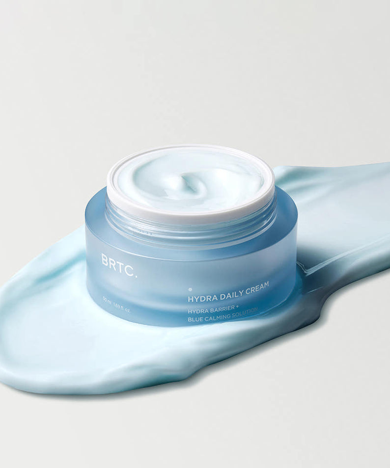 BRTC Hydra Daily Cream 50ml : crème hydratante BRTC sur fond clair, dans une touche de tissu bleu, visuel produit.