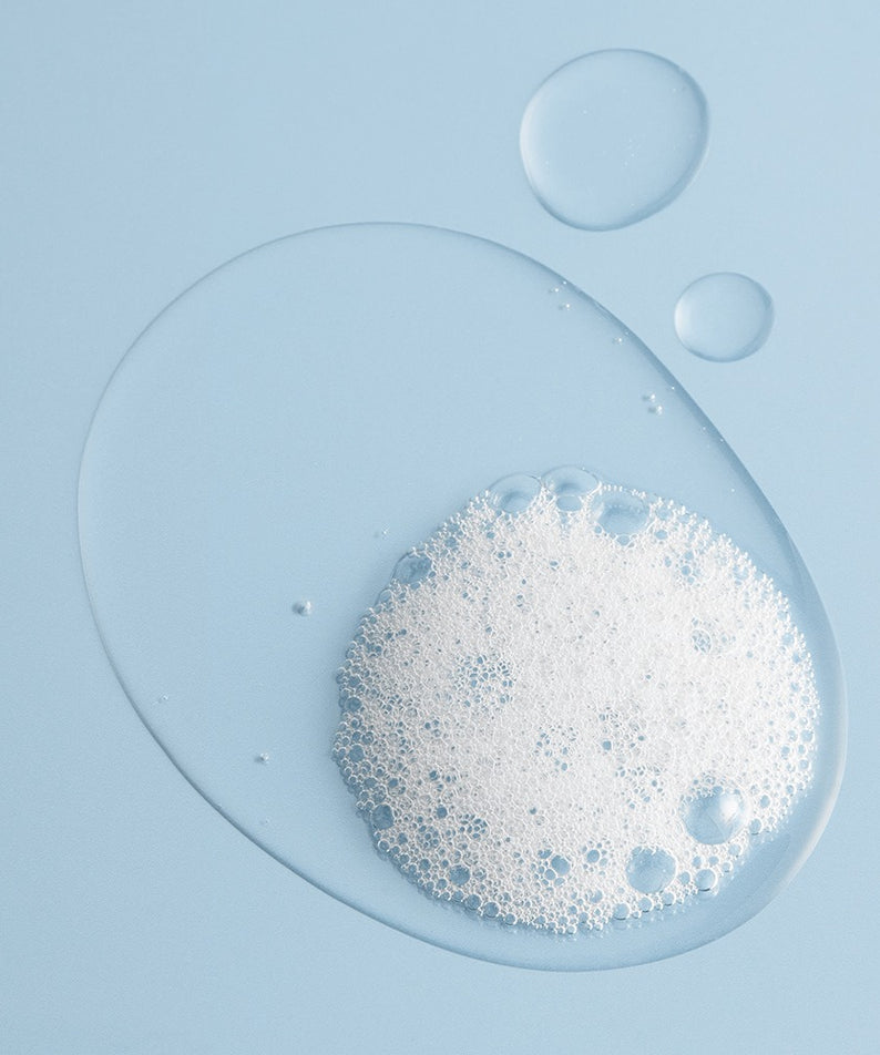 Gel moussant BRTC Power Homme Acne Solution Body Wash 500ml pour le soin de la peau, image de gouttes et mousse sur fond bleu.