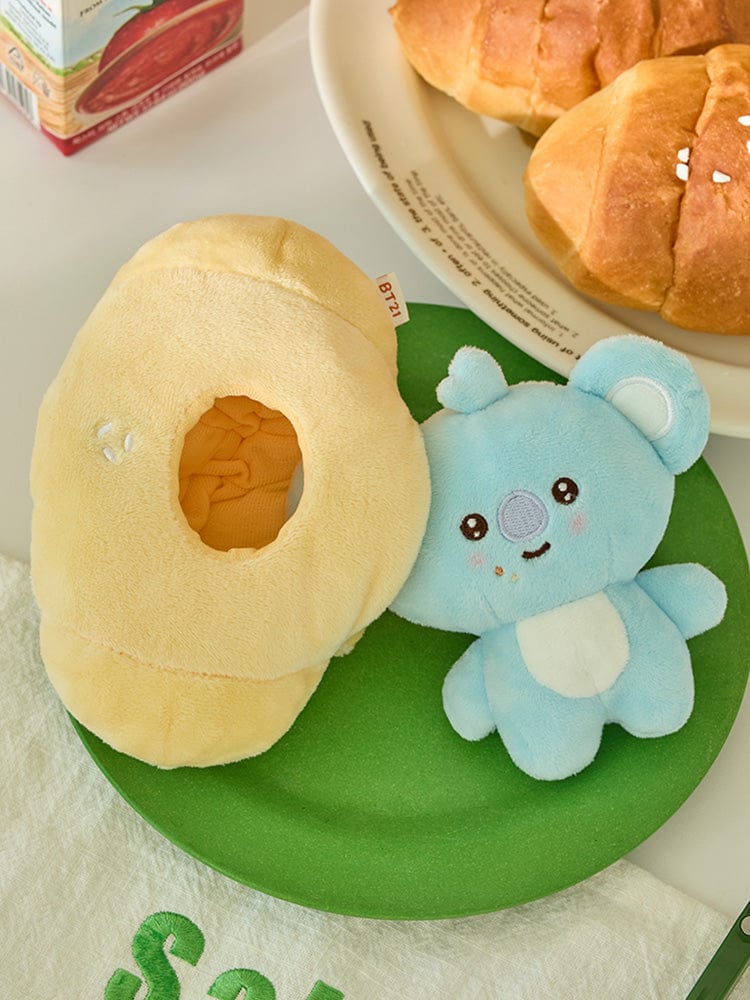 BT21 KOYA BABY COSTUME PLUSH DOLL BAKERY SHOP : peluche KOYA en costume boulanger sur fond vert avec mini pain