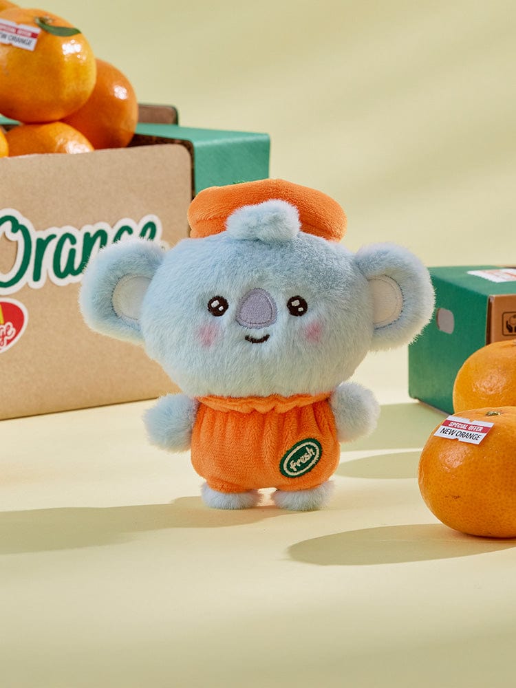 BT21 KOYA BABY PLUSH ORANGE PARTY peluche orange koala, officielle LINE, posée sur table avec boîte et décors.