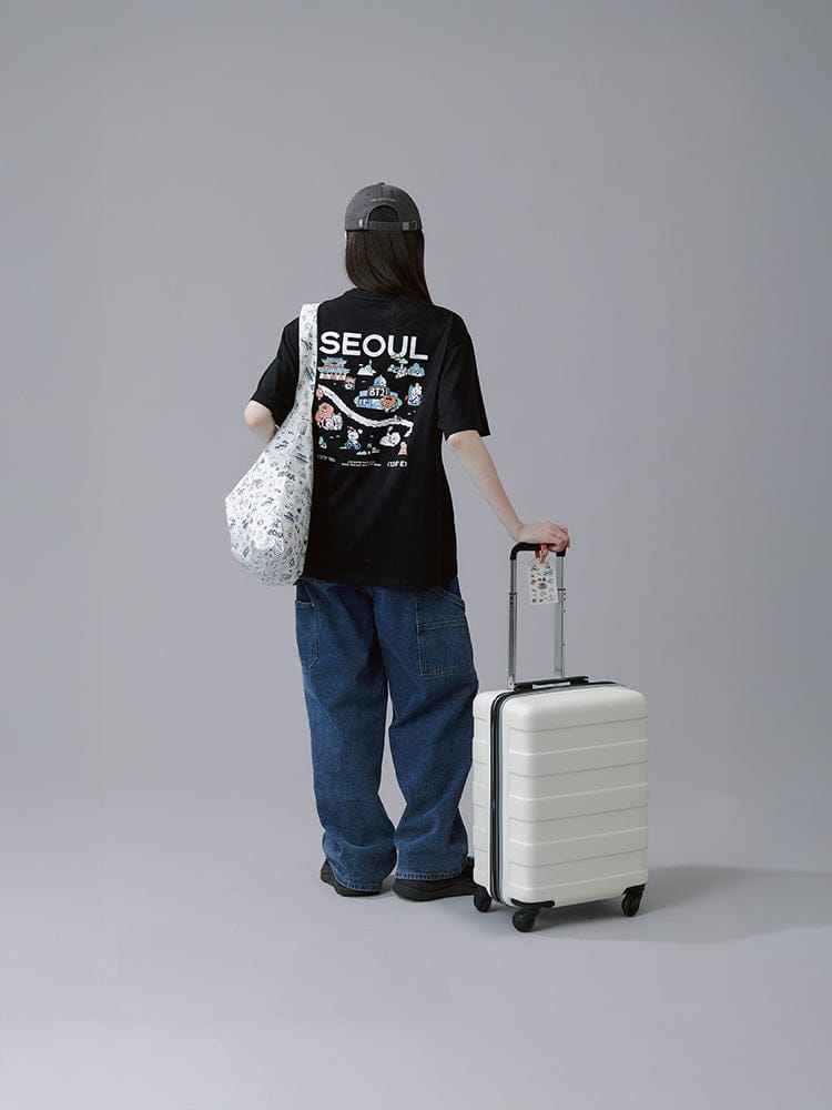 BT21 LUGGAGE TAG SEOUL EDITION LINE FRIENDS, sur valise blanche, personnage BT21 sur fond studio gris.